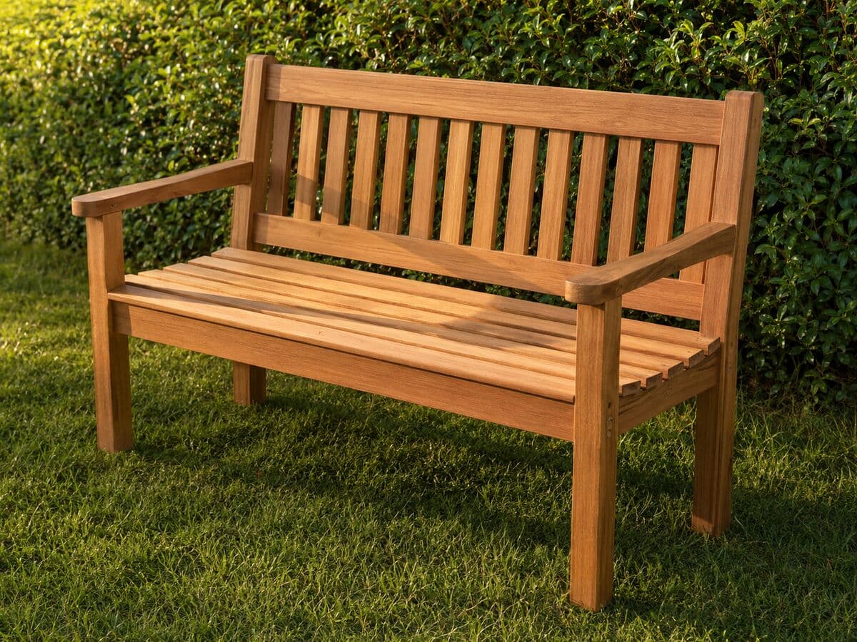 Slatted garden bench on a lawn in front of a hedge